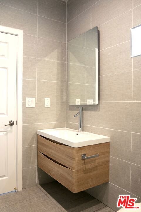 bathroom with tile walls and vanity