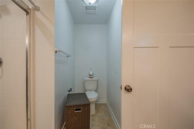 bathroom featuring toilet and a shower with shower door