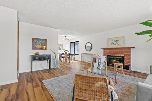 living room with a fireplace, wood-type flooring, and a textured ceiling