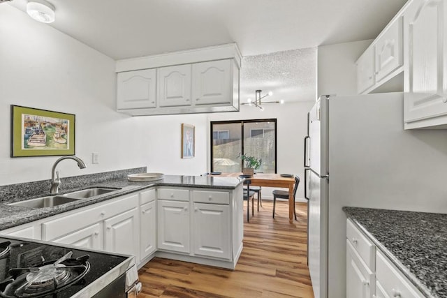 kitchen featuring white cabinets, light hardwood / wood-style floors, and sink