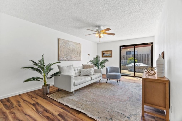 living room with hardwood / wood-style floors, ceiling fan, and a textured ceiling