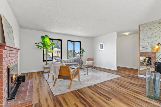 living room with a fireplace, wood-type flooring, and a textured ceiling