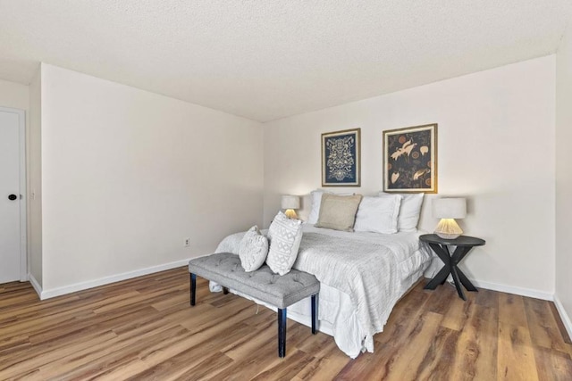 bedroom featuring hardwood / wood-style floors and a textured ceiling