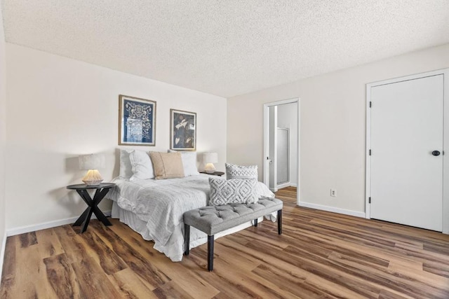 bedroom featuring a textured ceiling and dark hardwood / wood-style floors