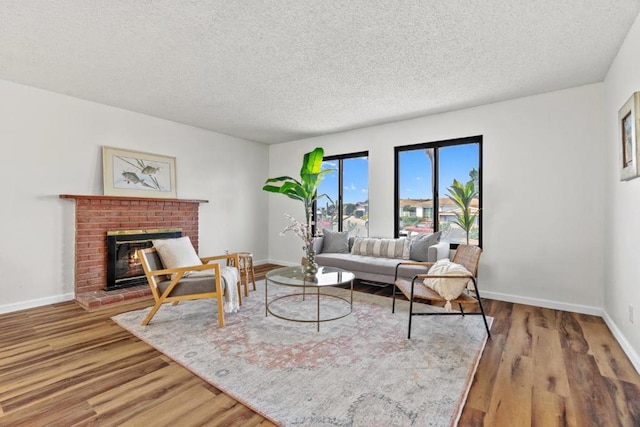 living room with hardwood / wood-style floors, a fireplace, and a textured ceiling