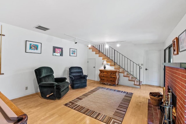 sitting room featuring track lighting, a fireplace, and hardwood / wood-style floors