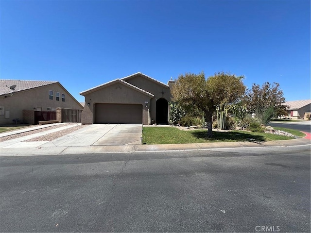 41097 Maiden Ct, Indio, CA 92203 - view of front of house featuring a garage, driveway, stucco siding, and a tile roof