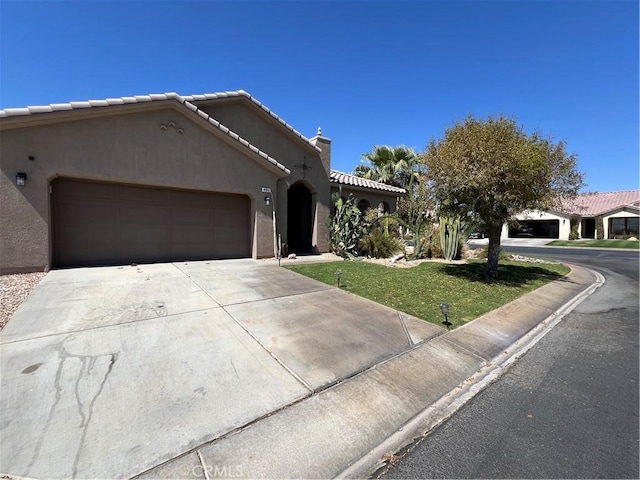 41097 Maiden Ct, Indio, CA 92203 - mediterranean / spanish house featuring an attached garage, stucco siding, driveway, a front yard, and a tile roof