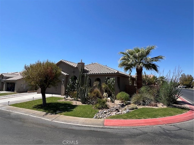 41097 Maiden Ct, Indio, CA 92203 - view of front of home with a garage, concrete driveway, a tile roof, stucco siding, and a front lawn