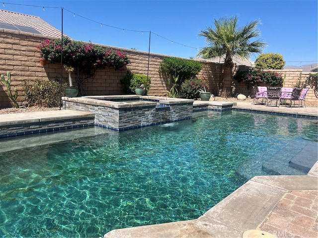 view of pool featuring pool water feature and an in ground hot tub