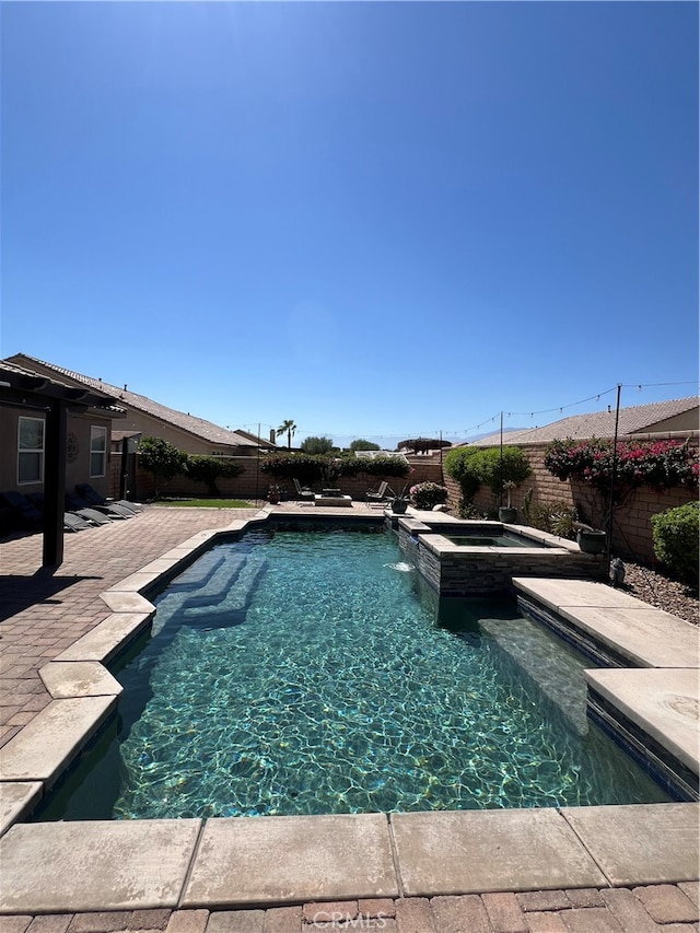 view of pool featuring a patio and an in ground hot tub