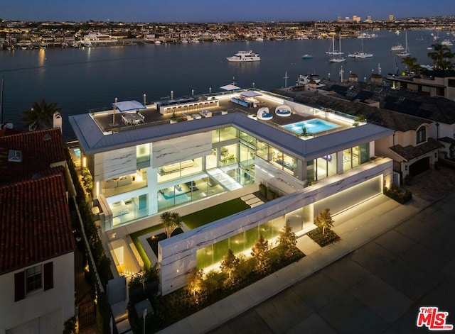 aerial view at twilight featuring a water view