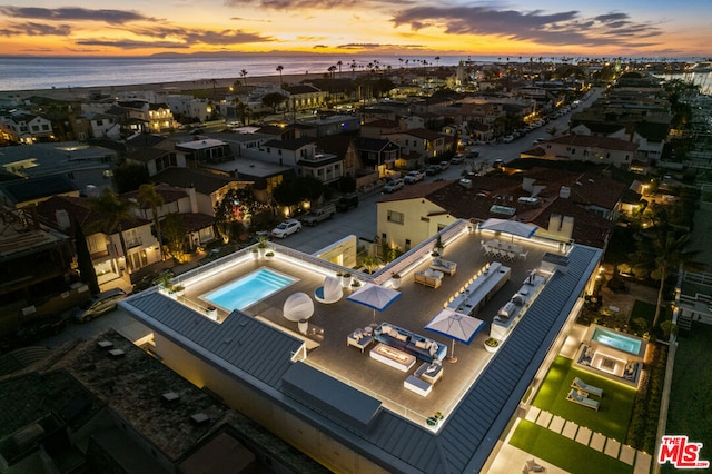 aerial view at dusk featuring a water view