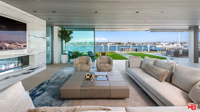 living room featuring a wall of windows, plenty of natural light, and a water view