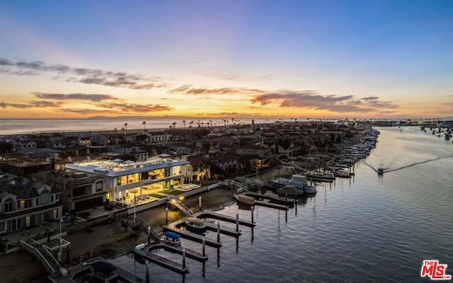 aerial view at dusk featuring a water view