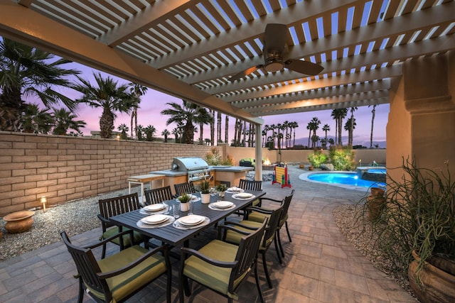 patio terrace at dusk with ceiling fan, grilling area, a pergola, and a fenced in pool