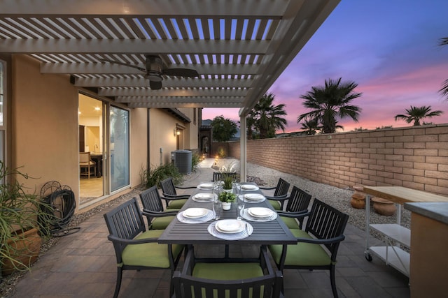 patio terrace at dusk featuring a pergola and central AC