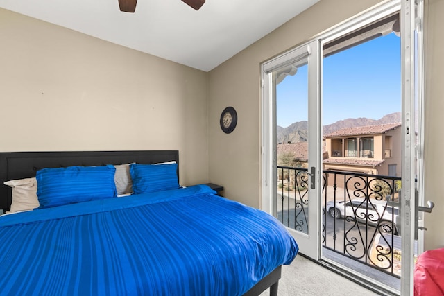 carpeted bedroom with ceiling fan, a mountain view, and access to exterior