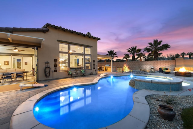 pool at dusk with a patio, an in ground hot tub, and ceiling fan