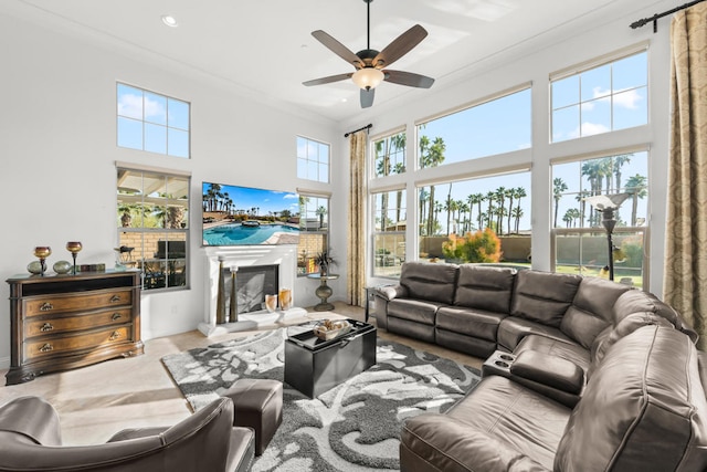 living room with crown molding, a towering ceiling, and ceiling fan