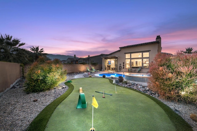 pool at dusk with a patio area