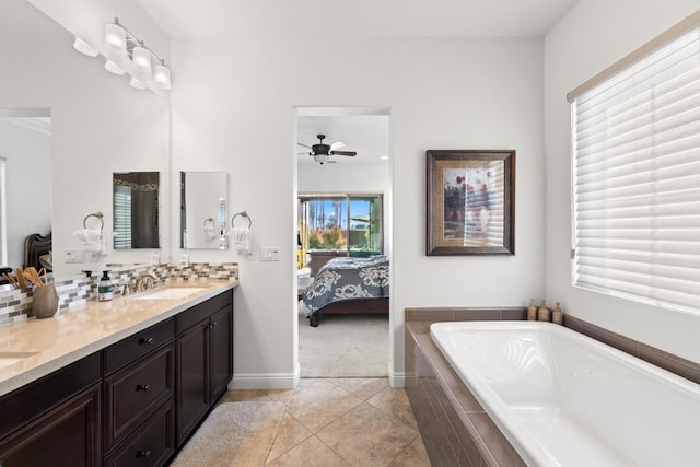 bathroom featuring plenty of natural light, vanity, ceiling fan, and a relaxing tiled tub