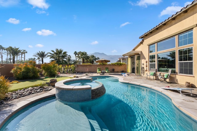 view of pool featuring a mountain view, a patio, and an in ground hot tub