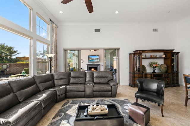 living room featuring ceiling fan, light tile patterned flooring, and ornamental molding