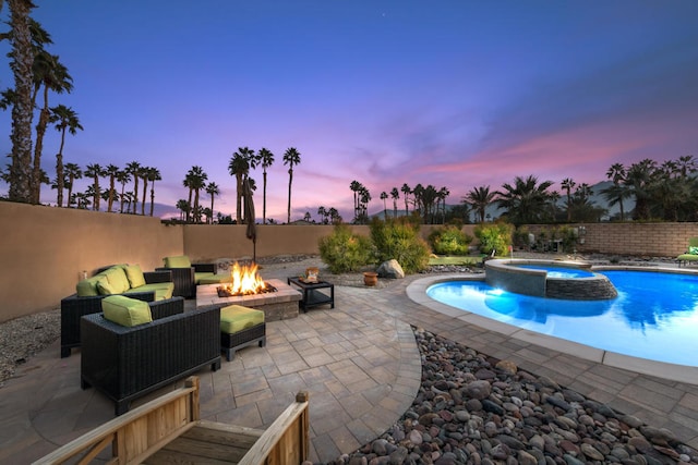 pool at dusk with an in ground hot tub, a fire pit, and a patio area