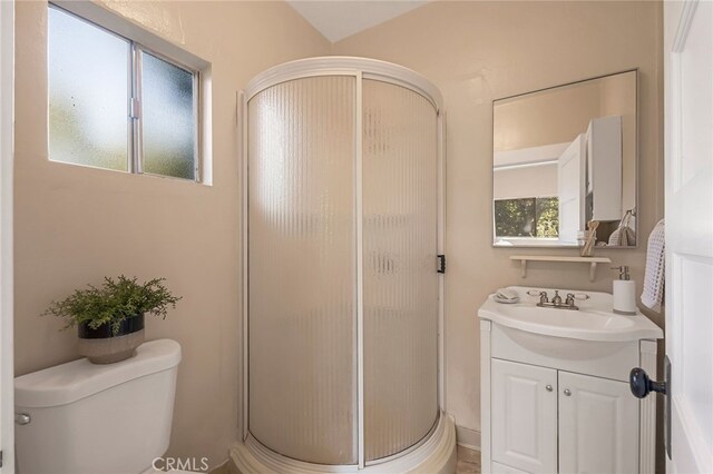 bathroom with a shower with door, vanity, and toilet