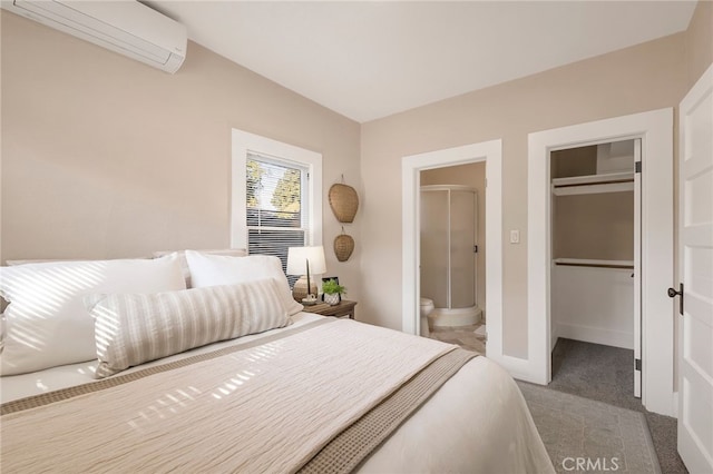 bedroom featuring carpet floors, a closet, connected bathroom, and a wall mounted air conditioner