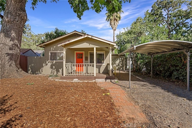 bungalow-style home featuring covered porch and a carport