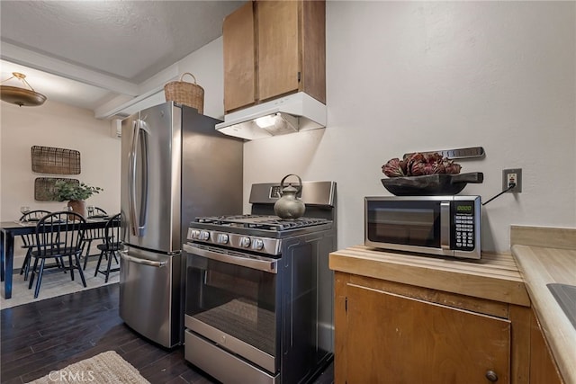 kitchen featuring appliances with stainless steel finishes, a textured ceiling, and dark wood-type flooring