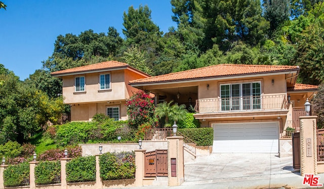 mediterranean / spanish home with a balcony and a garage