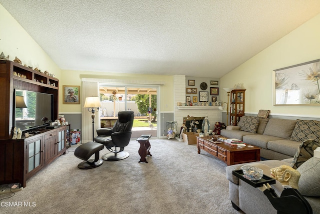 living room featuring vaulted ceiling, a textured ceiling, light colored carpet, and a fireplace