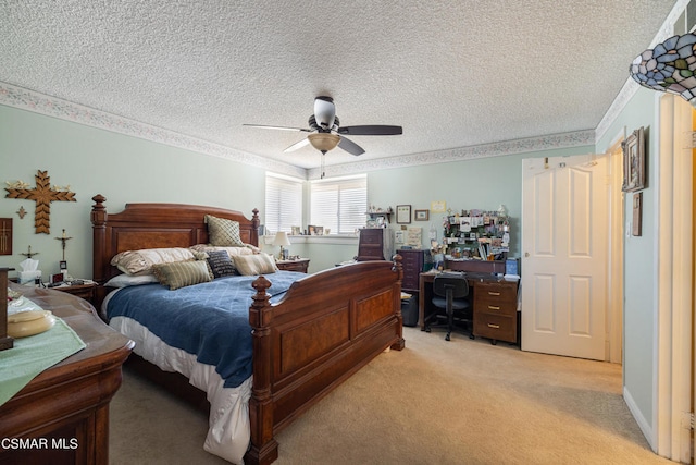 carpeted bedroom with ceiling fan and a textured ceiling