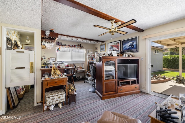 carpeted living room featuring ceiling fan and a textured ceiling