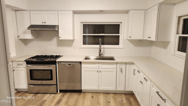 kitchen with white cabinetry, sink, light hardwood / wood-style flooring, and stainless steel appliances