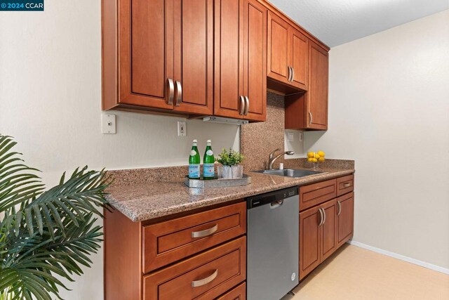 kitchen with dishwasher, sink, and dark stone counters