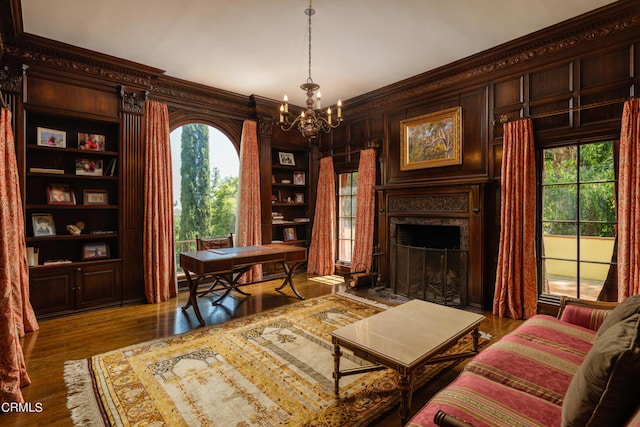 office with ornamental molding, dark hardwood / wood-style flooring, built in features, and a notable chandelier