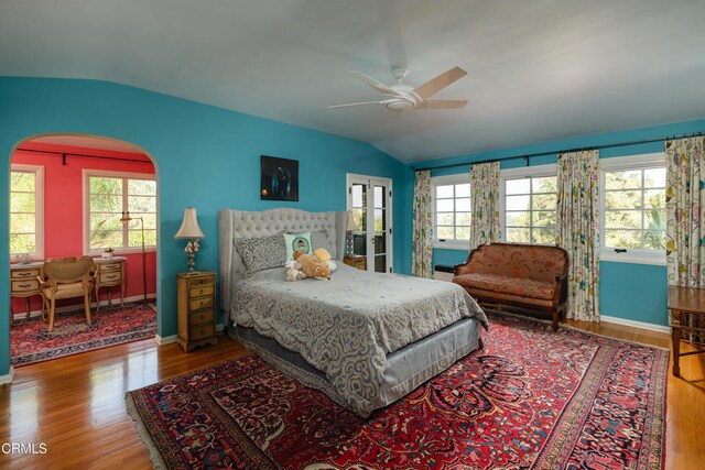 bedroom with multiple windows, lofted ceiling, and hardwood / wood-style floors