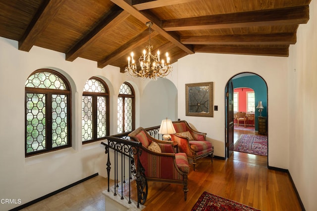 corridor featuring wood-type flooring, a notable chandelier, lofted ceiling with beams, and wooden ceiling