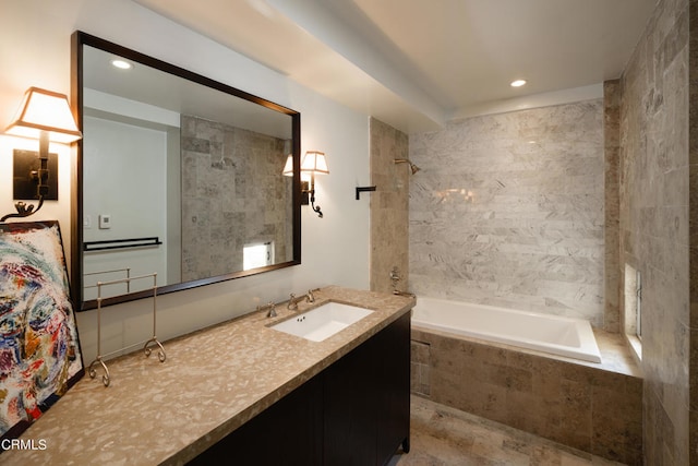 bathroom featuring tiled shower / bath and vanity