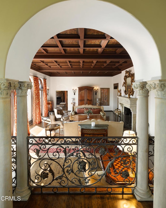 living room with wood-type flooring, beamed ceiling, coffered ceiling, and ornate columns