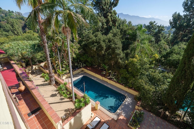 view of swimming pool with a mountain view and a patio area