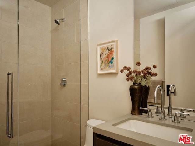 bathroom with vanity, toilet, and a shower with shower door