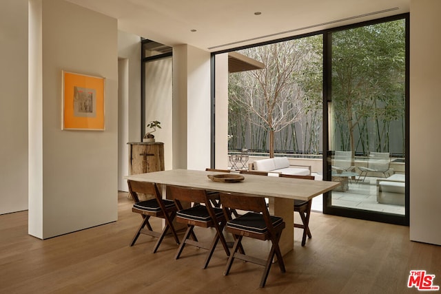 dining room with floor to ceiling windows and hardwood / wood-style flooring