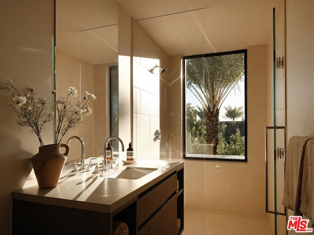 bathroom with a shower, vanity, and tile patterned floors