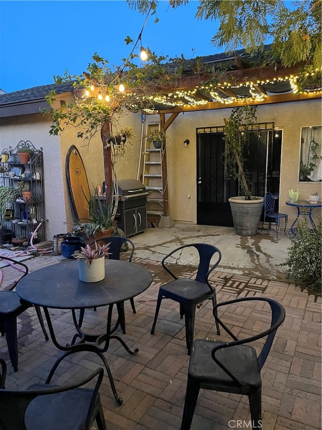 patio terrace at dusk featuring area for grilling