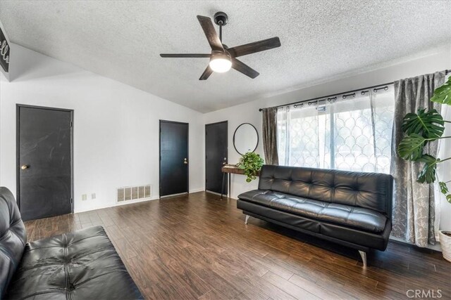 living room with a textured ceiling, vaulted ceiling, dark hardwood / wood-style flooring, and ceiling fan